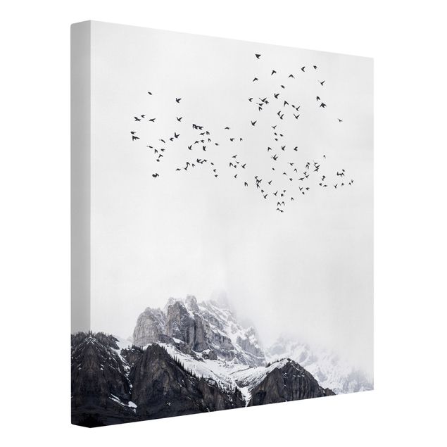 Canvas schilderijen Flock Of Birds In Front Of Mountains Black And White