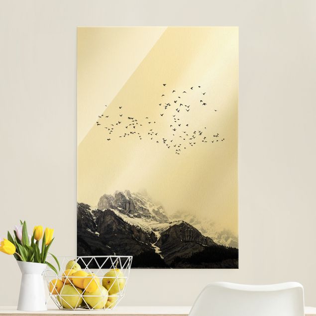 Glasschilderijen Flock Of Birds In Front Of Mountains Black And White